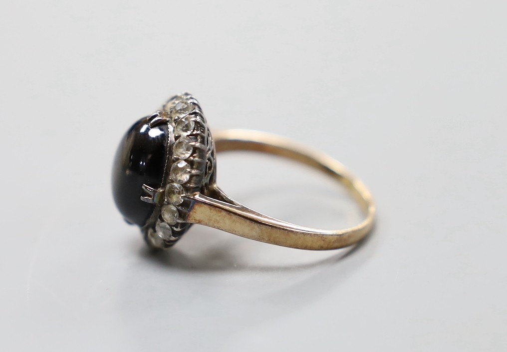 A 14k yellow metal, star sapphire and white sapphire? set oval cluster ring, size N, gross weight 4.5 grams.